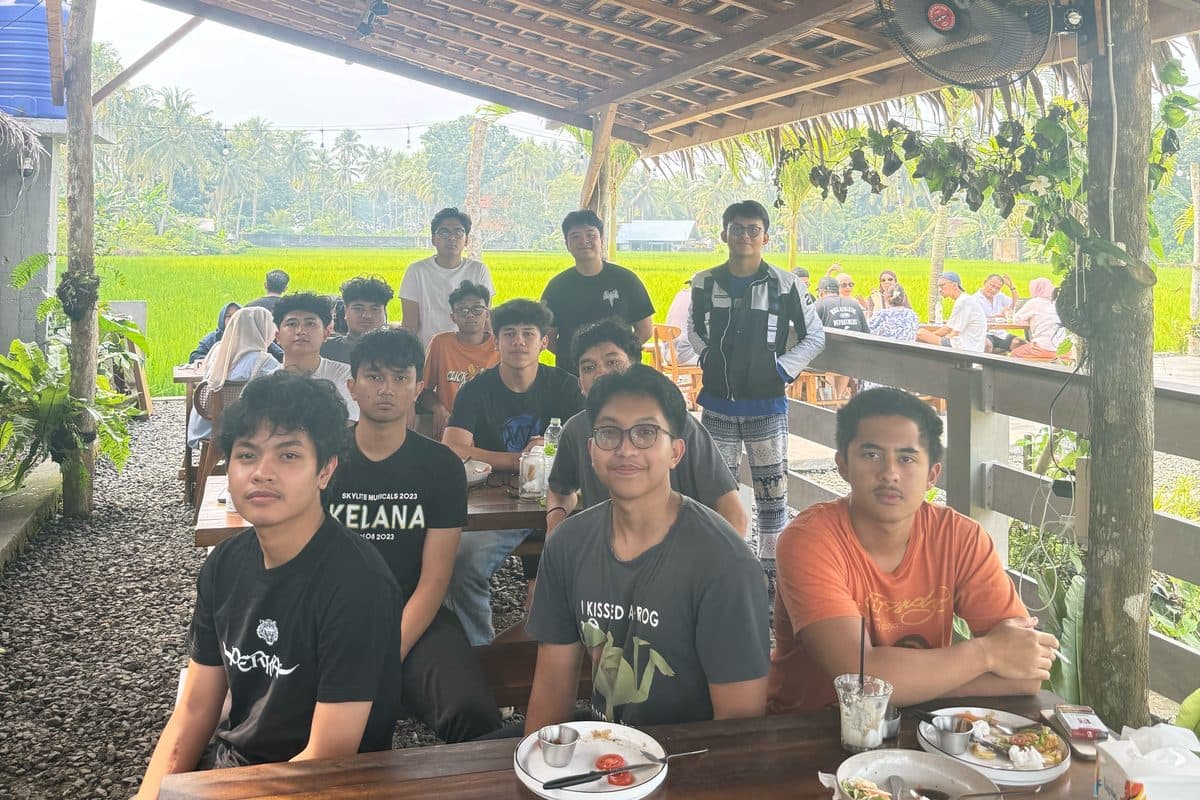 Friends sharing lunch at a gazebo by the rice fields