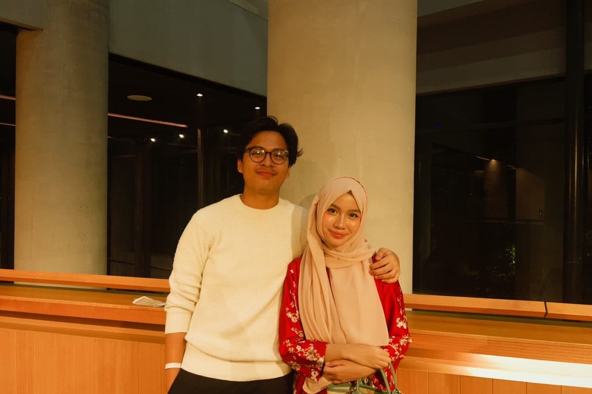Dhanes with a friend inside a building at night