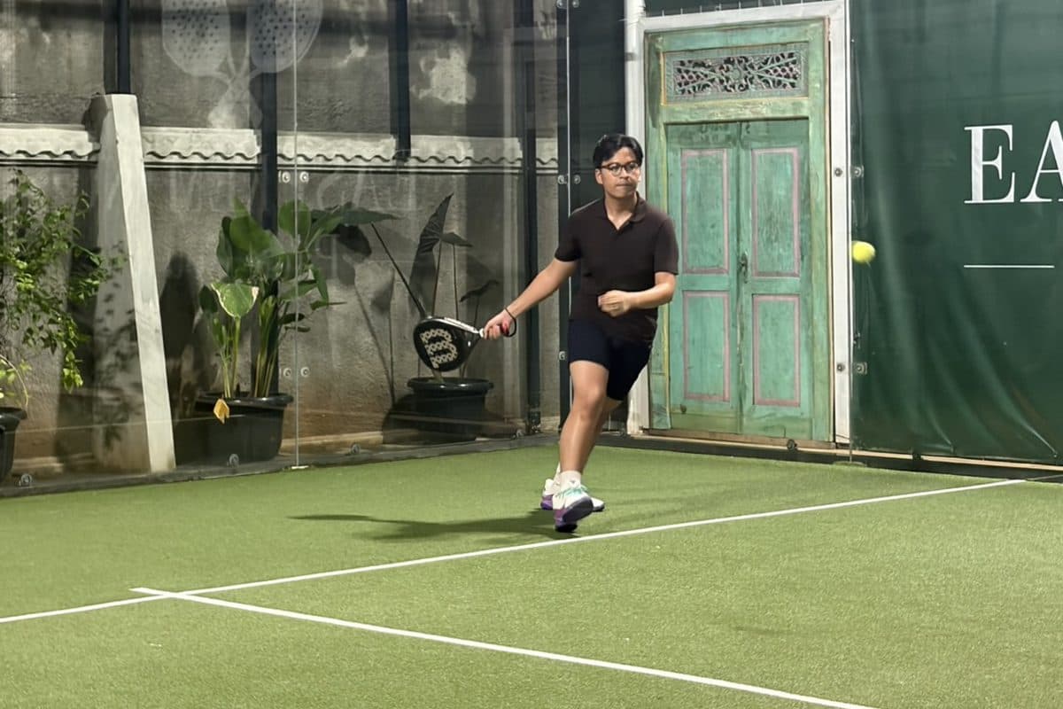 Dhanes playing on an outdoor padel court