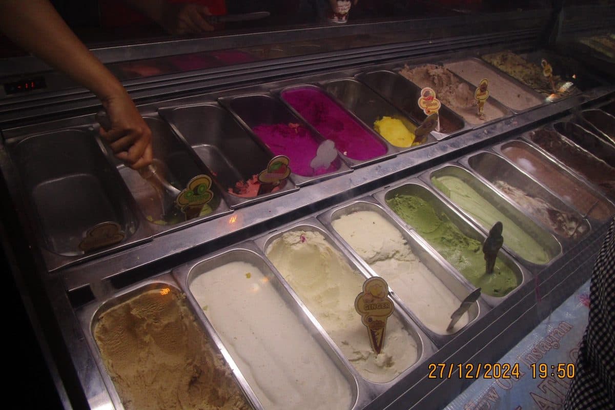 A gelato display case with many flavors