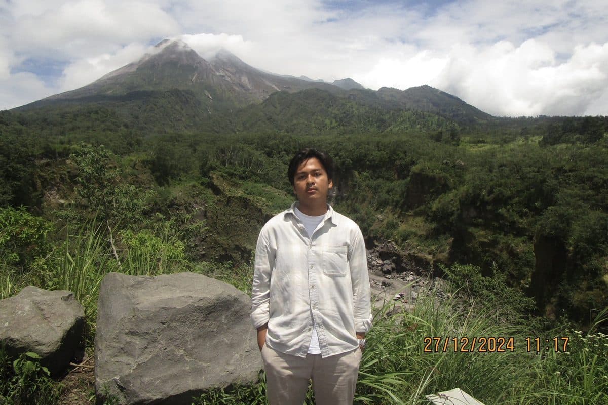 Dhanes standing in front of a volcano
