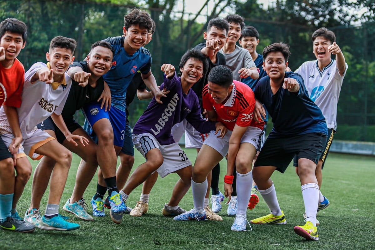 Friends posing together on a football pitch